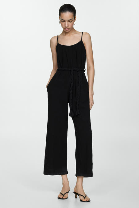 Combinaison noire de MANGO avec une ceinture tressée et des jambes larges, associée à des talons aiguilles.