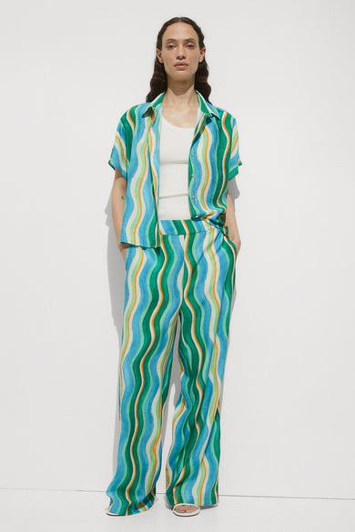 Pantalon vert 7/8 de MANGO en bleu avec des rayures ondulantes bleues, oranges et blanches.
