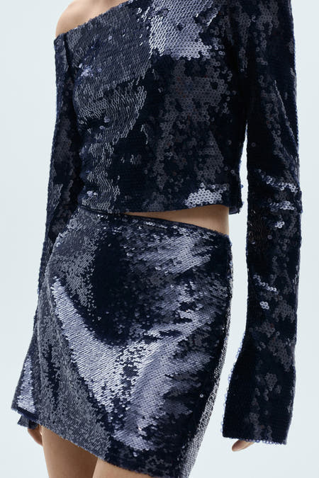 Short blue skirt from MANGO, with sequins and a slit on the side, back.