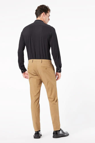 Beige chino van DOCKERS, gezien van achteren, met een zwarte blouse en zwarte schoenen.