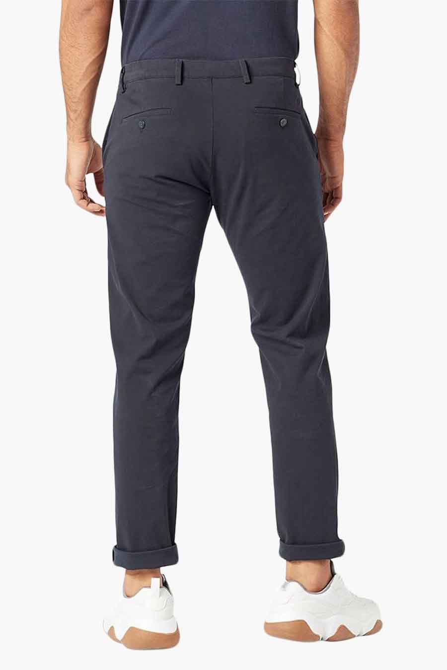 Jean bleu de DOCKERS, vu de l'arrière, avec des revers et des chaussures blanches.