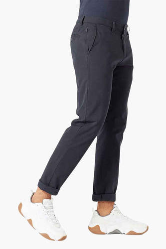 Jean chino bleu de DOCKERS, vu de côté avec des revers et des sneakers blanches.