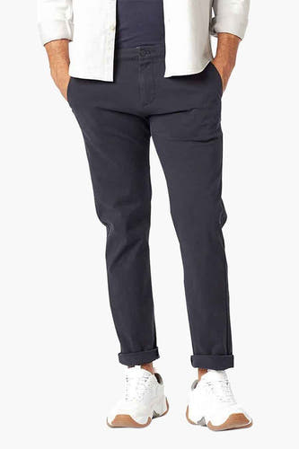 Chino bleu de DOCKERS, avec des revers et des sneakers blanches.