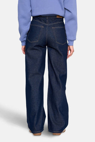 Jean denim bleu marine large de 24 Colours GMBH, avec des poches arrière et une étiquette en cuir sur la ceinture.