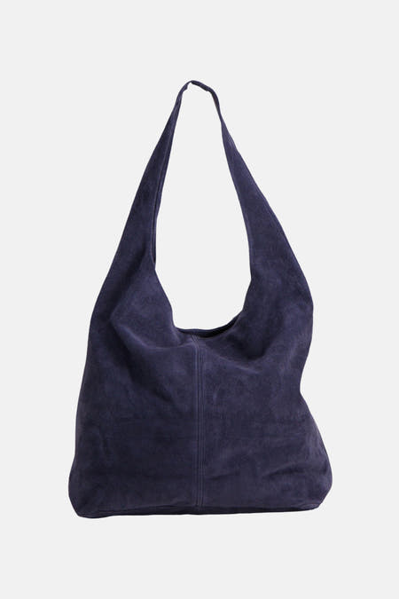 Sac à bandoulière en daim violet foncé d'Access®, style hobo souple porté par le mannequin en noir.
