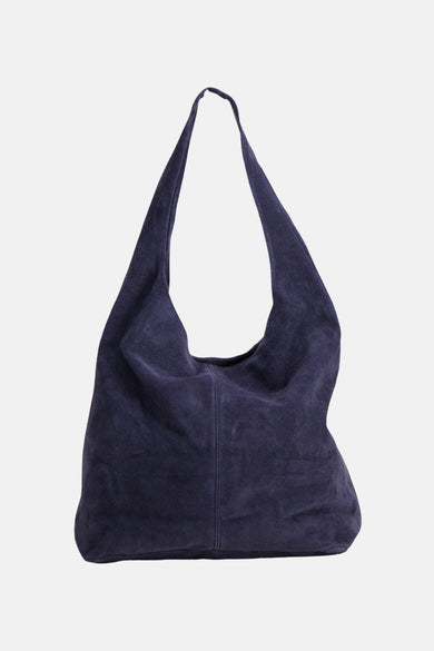 Sac à bandoulière en daim violet foncé d'Access®, style hobo souple porté par le mannequin en noir.