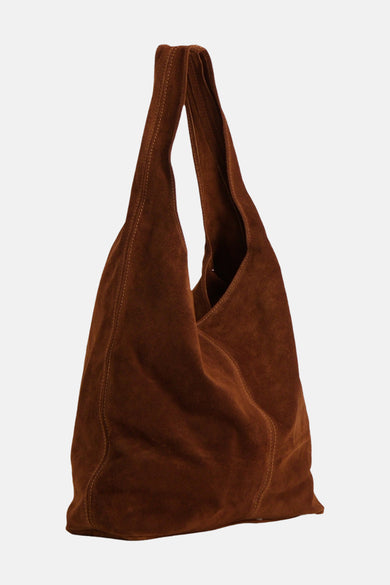 Sac à bandoulière en daim marron d'Access® avec une forme souple, tenu par un mannequin.
