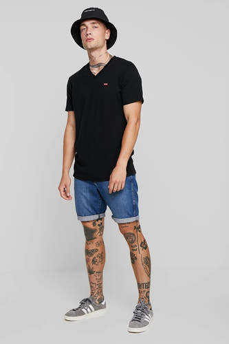 T-shirt noir à manches courtes de Levi's, porté avec un pantalon en denim et un chapeau bucket.