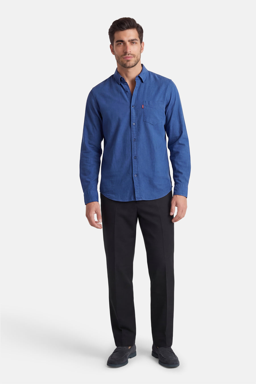 Blauw overhemd met lange mouwen van Levi's®, met knoopsluiting en borstzak, gecombineerd met zwarte pantalon en suède loafers.
