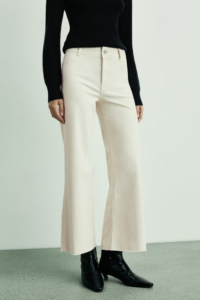 Jean blanc cassé large de MANGO, avec une taille haute et des chaussettes noires.