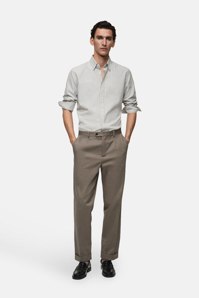 Chemise verte à manches longues de MANGO, avec un motif rayé subtil, associée à des pantalons bruns et des chaussures noires.