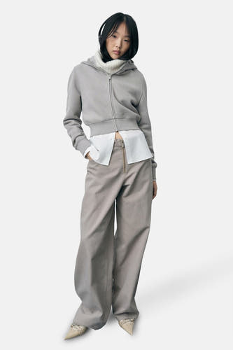 Pantalon beige de MANGO, avec des jambes larges et une tenue avec un t-shirt blanc et une hoodie.