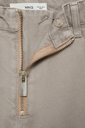 Jeanne femme beige de MANGO, avec une fermeture éclair distinctive et une fermeture à glissière.