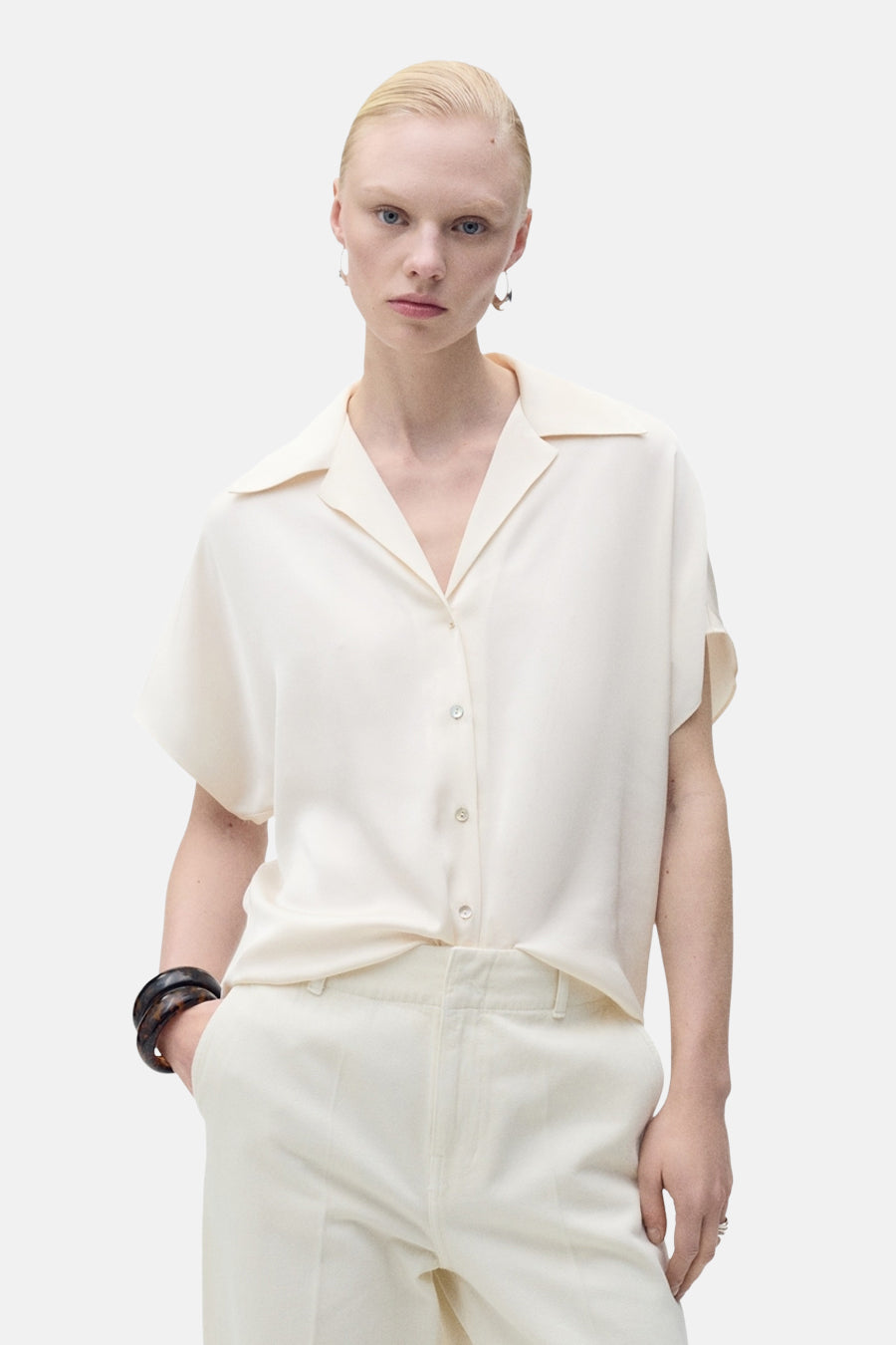 Chemise écru à manches courtes de MANGO, vue de derrière avec une coupe décontractée et un tissu lisse.