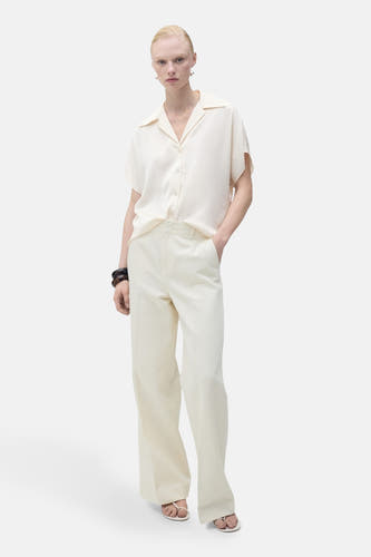 Chemise écru à manches courtes de MANGO, avec un col ouvert et une coupe droite.