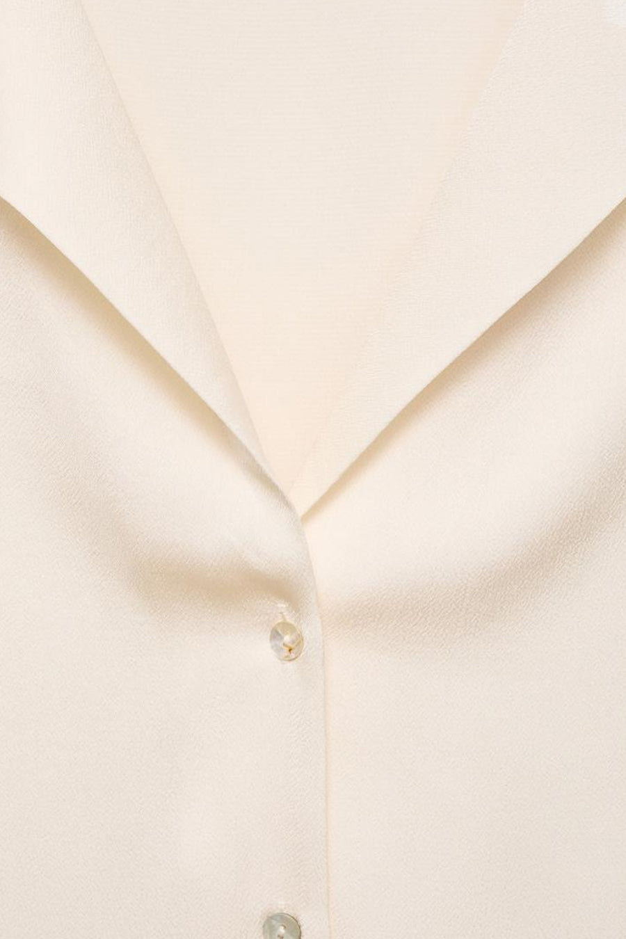 Chemise écru à manches courtes de MANGO, avec un col ouvert et une fermeture à boutons.