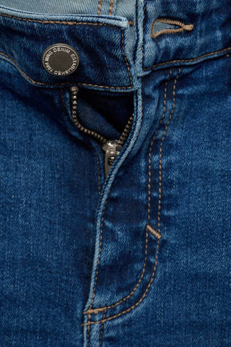 Jean skinny en denim bleu de MANGO, avec boutons et fermeture éclair.