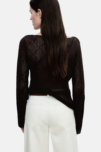 Pull marron avec col rond de MANGO, en tissu dégagé, associé à un pantalon blanc.
