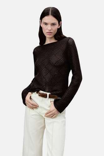 Pull marron avec col rond de MANGO, avec des manches courtes et porté avec un pantalon blanc et une ceinture marron.