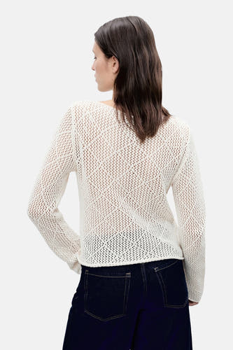 T-shirt écru avec col rond de MANGO, à structure ouverte, associé à des jeans foncés.