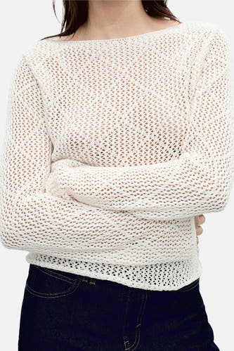 T-shirt écru avec col rond de MANGO, avec un décolleté ouvert et des jeans foncés.