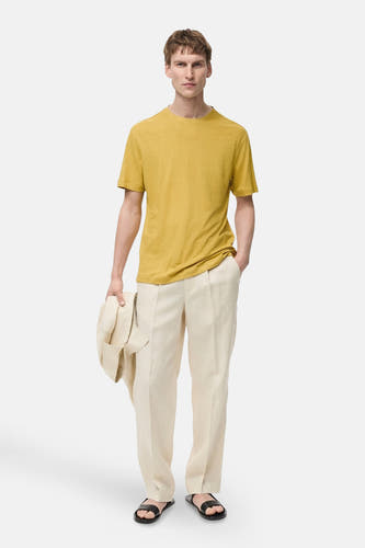 T-shirt jaune à manches courtes de MANGO, avec un pantalon en lin décontracté et des sandales.