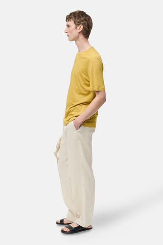 T-shirt jaune à manches courtes de MANGO, porté avec un short en lin crème et des sandales noires, vue arrière.