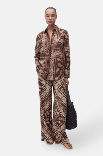 Chemise brune à longues manches de MANGO, avec un motif paisley et portée avec une jupe coordonnée.