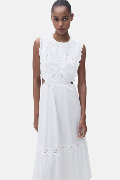 Robe blanche sans manches de MANGO, avec des détails brodés sur le haut et le bas et des découpes sur les côtés.