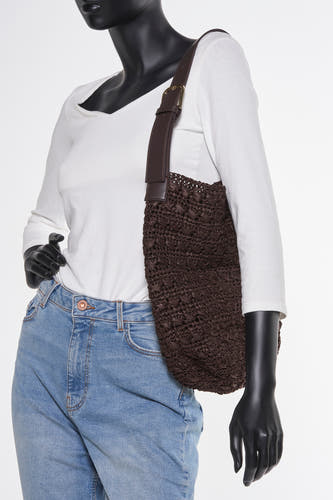 Veste épaule MANGO marron, avec une texture tressée et un panneau d'épaule plus foncé, portée sur une chemise blanche et des jeans bleus.