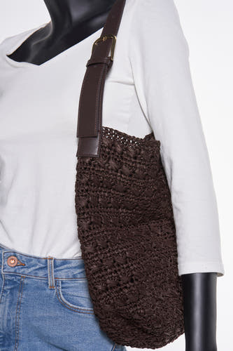Veste épaule brune de MANGO, texture tissée, portée sur un chemisier blanc et des jeans bleus.