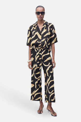 Zwarte broek van MANGO, met beige abstracte zebraprint en een bijpassende riem.
