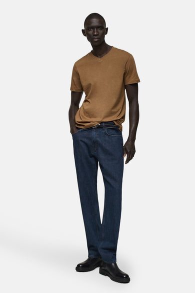 T-shirt marron à manches courtes de MANGO, avec un col V et associé à des jeans foncés et des bottes noires.