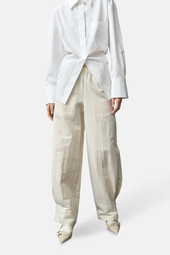 Jean écru de MANGO, avec une jambe large et des plis subtils à la base, à voir avec des chaussures pointues.