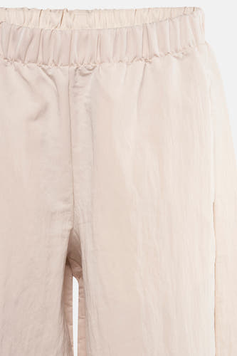 Pantalon écru de MANGO, avec une ceinture élastique et un subtil brillant.
