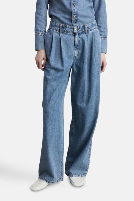 Jean décontracté de denim bleu moyen de MANGO, avec des plis et associé à un chemise en denim.