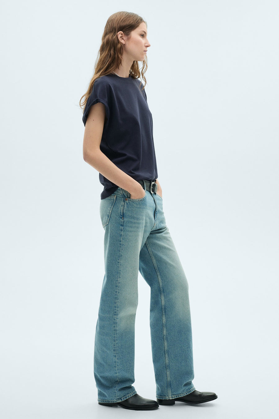 T-shirt bleu marine à manches courtes de MANGO, porté avec une ceinture et des jeans larges.