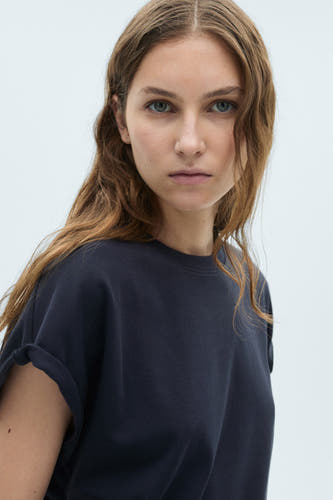 T-shirt bleu marine à manches courtes de MANGO, avec des manches retroussées et une texture lisse.