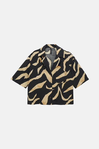 Chemise noire à manches courtes de MANGO avec un imprimé zèbre beige et une poche poitrine.