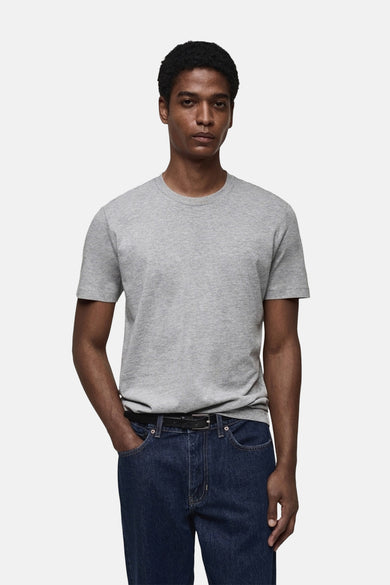 T-shirt gris à manches courtes de MANGO, porté avec des jeans foncés et une ceinture noire.