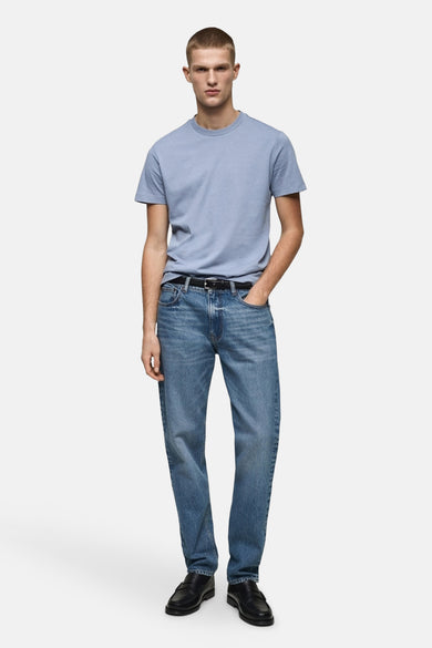 T-shirt bleu à manches courtes de MANGO, associé à des jeans et des chaussures noires.