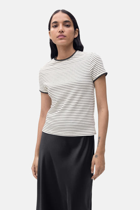 T-shirt beige à manches courtes de MANGO, avec un motif rayé noir et des bords décoratifs sur les manches.