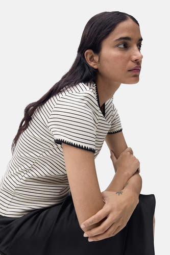 T-shirt beige à manches courtes de MANGO, avec des rayures noires et un bord côtelé sur les manches.