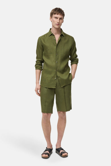 Short vert de MANGO, porté avec un chemisier en lin coordonné et des sandales noires.