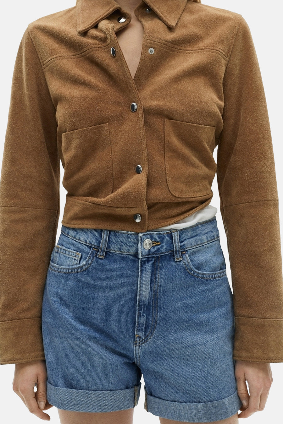 Bruine suède jas en blauwe denim shorts.