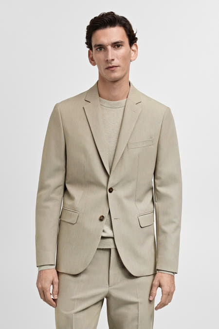 Blazer beige de MANGO, avec détail de boutons sur les manches à l'arrière.