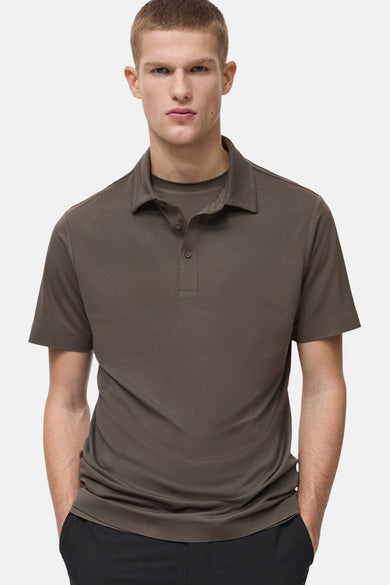 Kaki polo avec des manches courtes de MANGO, vue arrière, associé à une jupe noire.