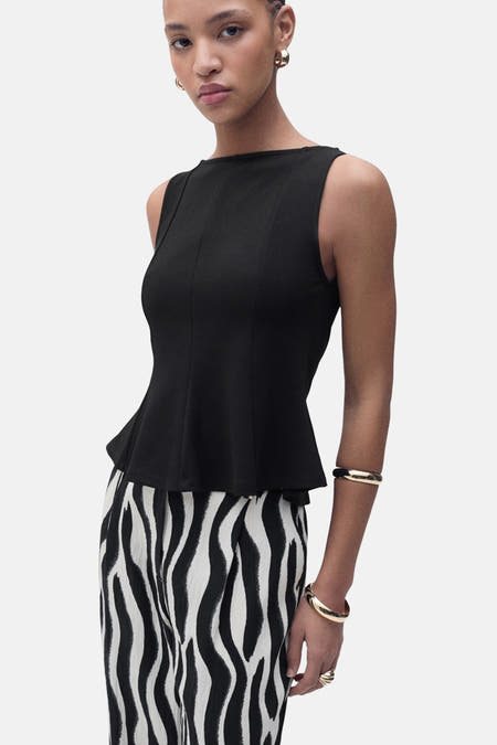 T-shirt noir sans manches de MANGO, associé à un pantalon imprimé zèbre.