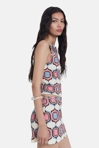 Jupe courte multicolore de MANGO, avec un motif géométrique rétro et une ceinture en chaîne argentée.