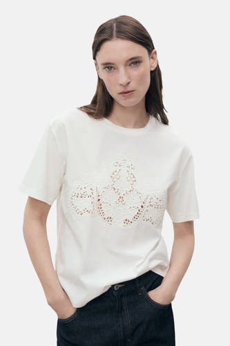 T-shirt blanc à manches courtes de MANGO, avec une coupe décontractée et un col droit.